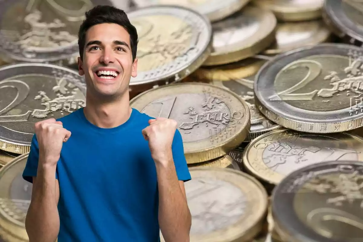 Muntatge amb una imatge de monedes de 1 i 2 euros de fons. En primer terme un home somrient i en posició de celebrar alguna cosa
