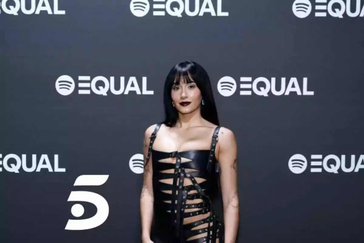 Una persona posando frente a un fondo con el logo de Spotify y la palabra "Equal".