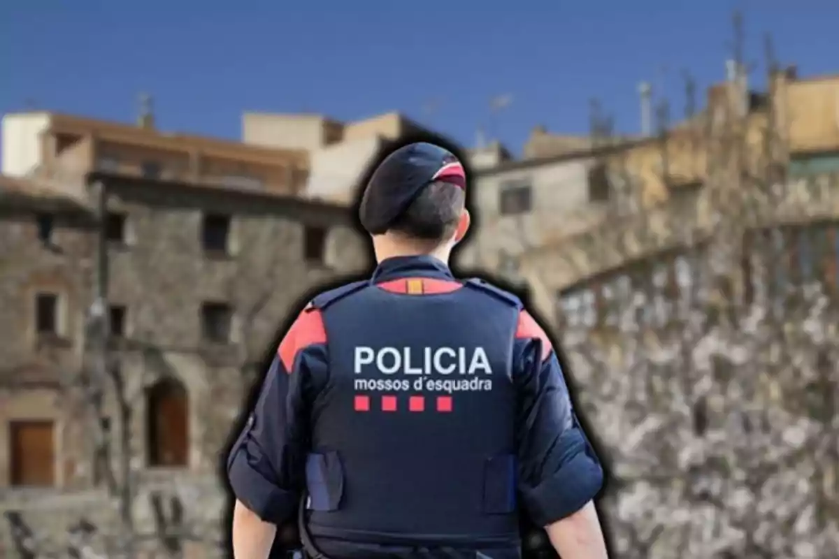 Un agent dels Mossos d'Esquadra d'esquena amb fons d'edificis antics.