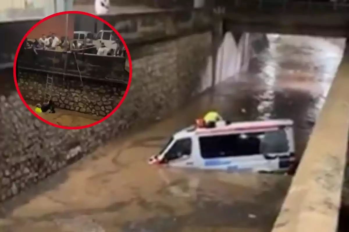 Una ambulancia parcialmente sumergida en un canal inundado mientras un grupo de personas observa desde un puente cercano y un rescatista desciende por una escalera.