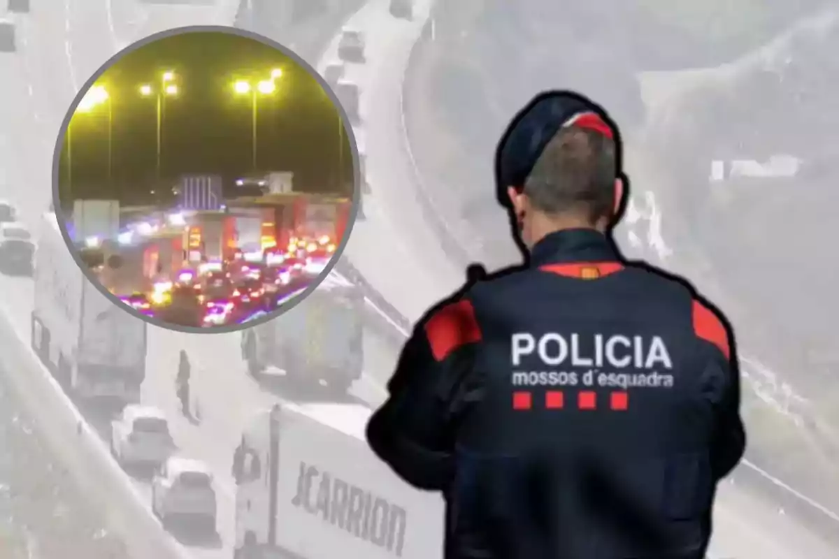 Un agent de policia observa una carretera amb trànsit detingut i llums d'emergència.