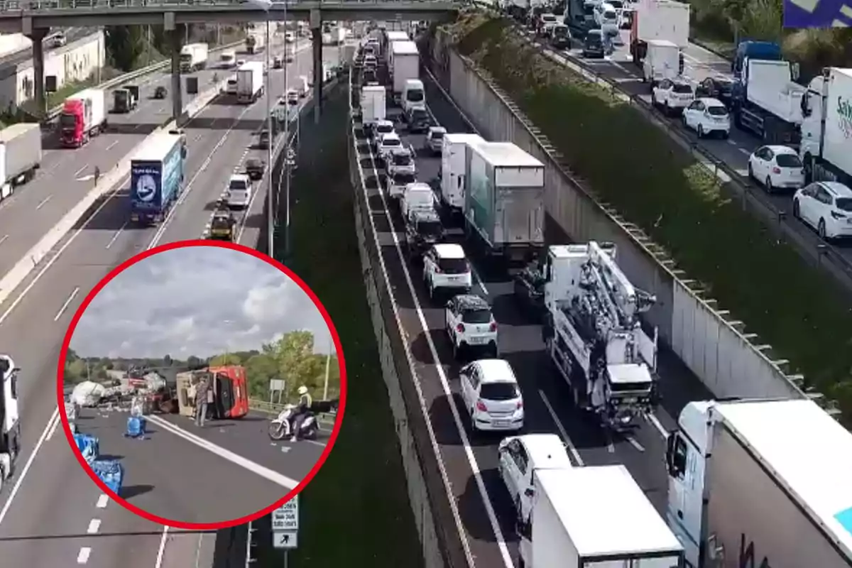 Una carretera amb trànsit dens i un accident en un carril, on un vehicle està bolcat i hi ha persones al voltant.