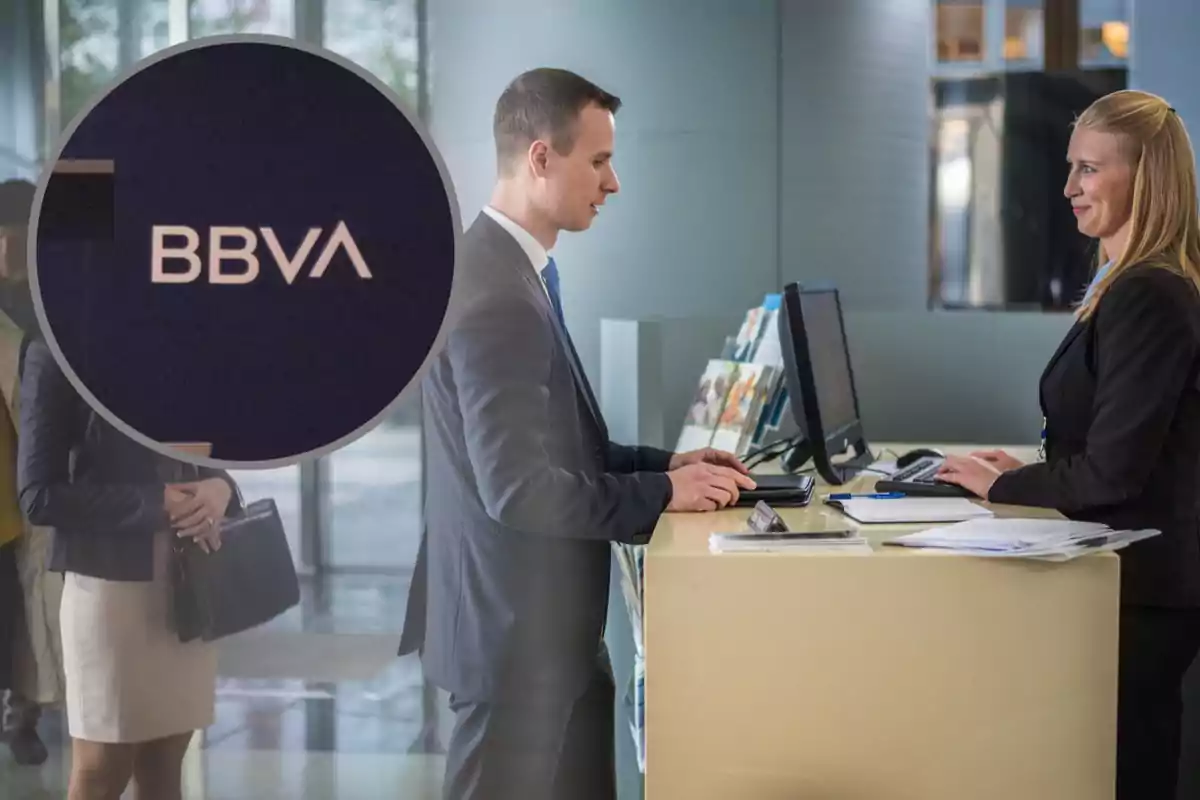 Un home i una dona interactuen en un taulell de banc amb el logotip de BBVA destacat en un cercle.