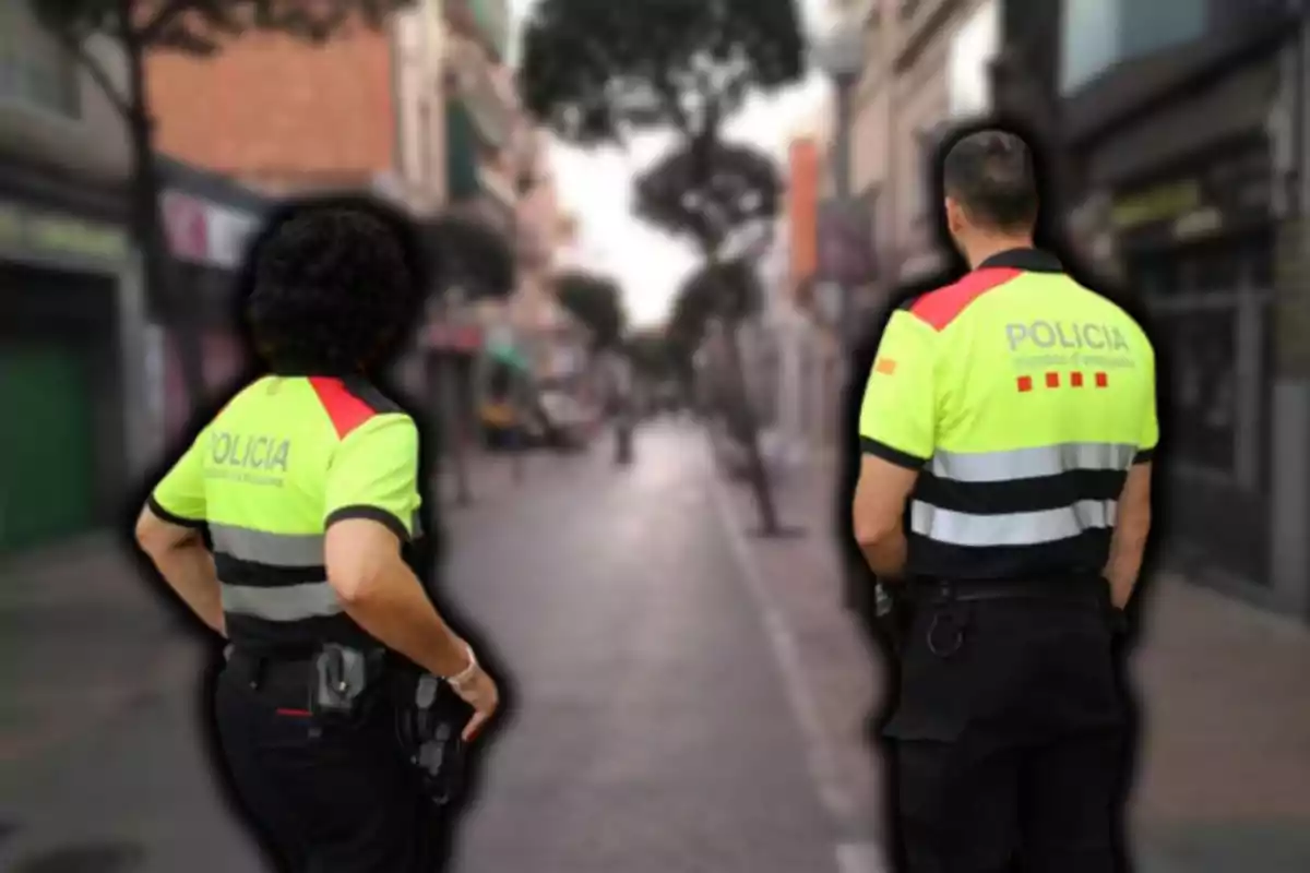 Dos agentes de policía patrullando una calle urbana.