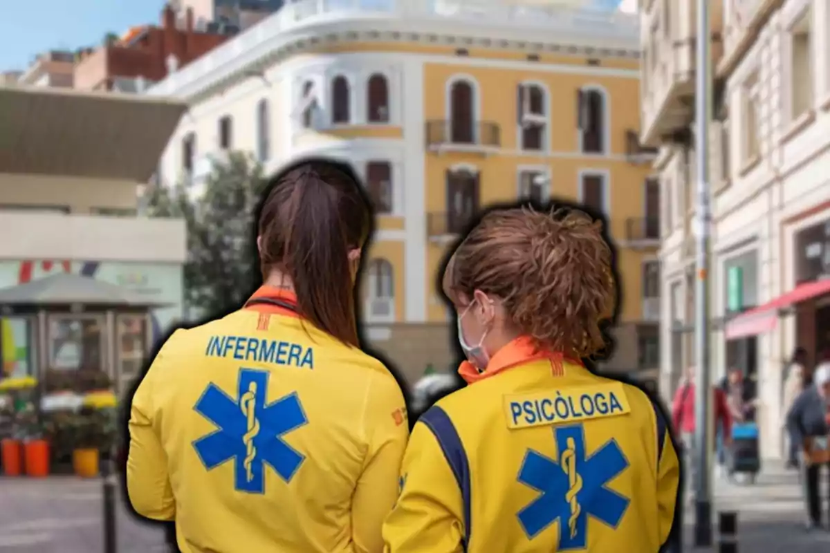 Dos profesionales de la salud con uniformes amarillos en una calle urbana.