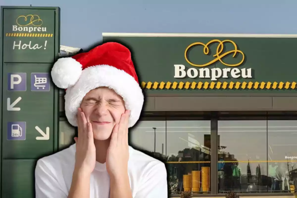 Un jove amb gorra de Nadal davant un supermercat Bonpreu.