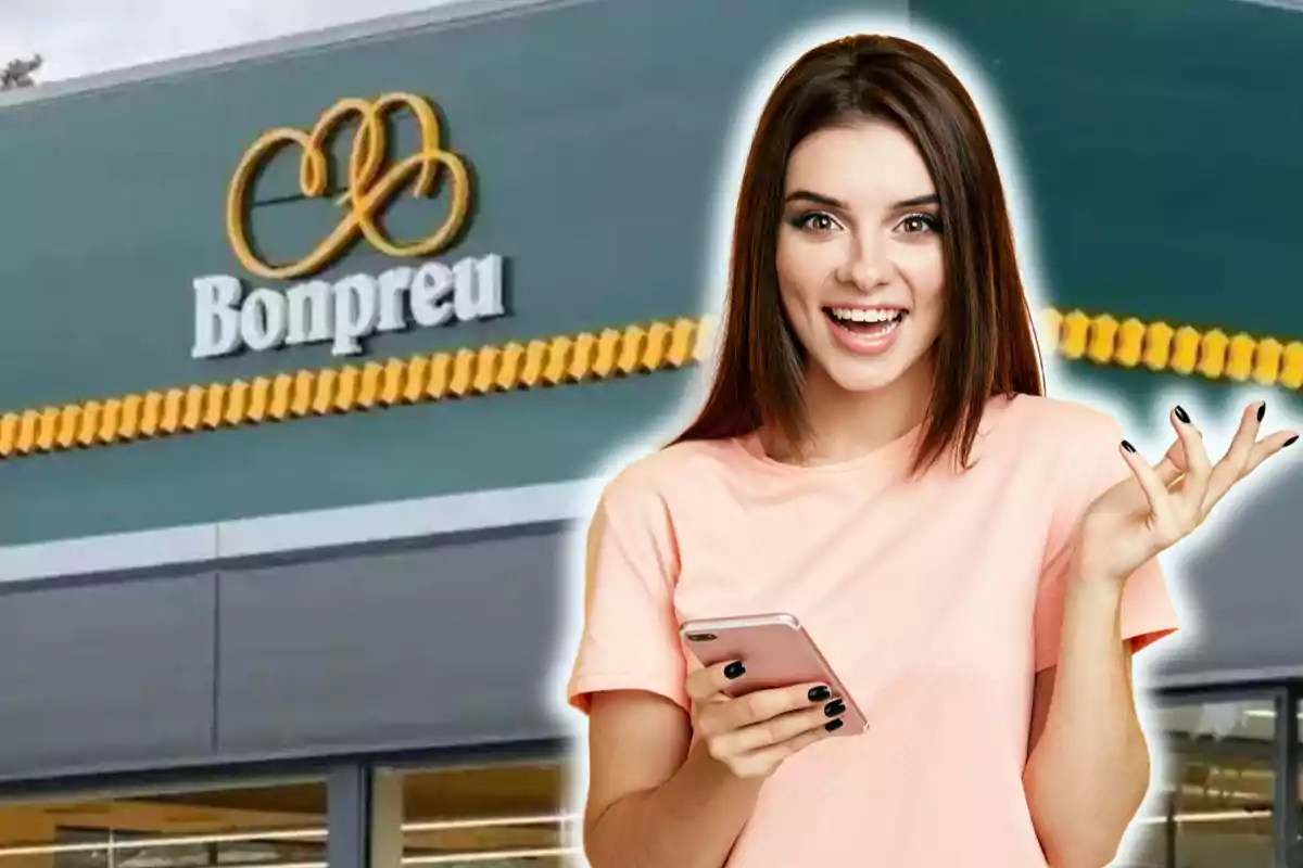 Una mujer sonriente sostiene un teléfono frente a un supermercado Bonpreu.