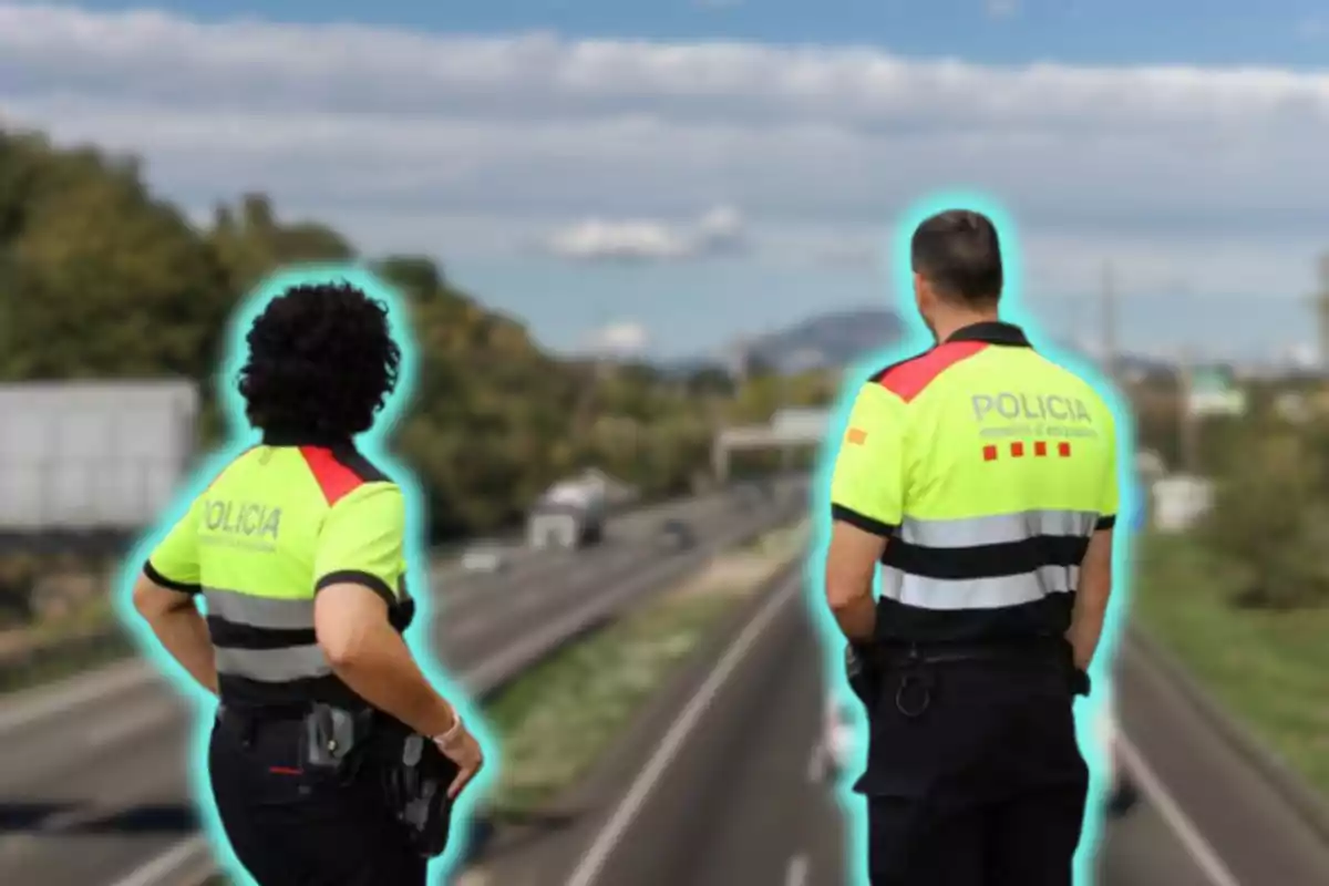 Dos agents de policia amb uniformes reflectors observen una carretera des d'un pont.