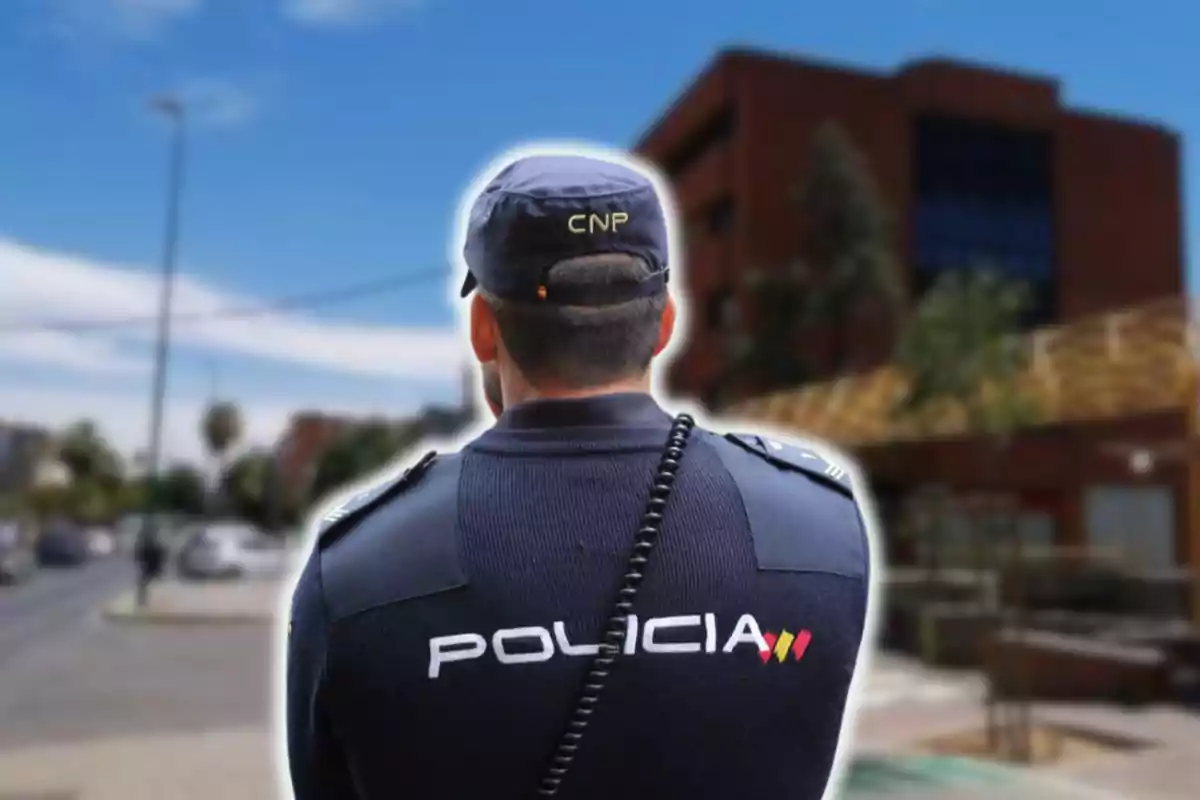 Un policia d?esquena amb uniforme i gorra en un carrer urbà.