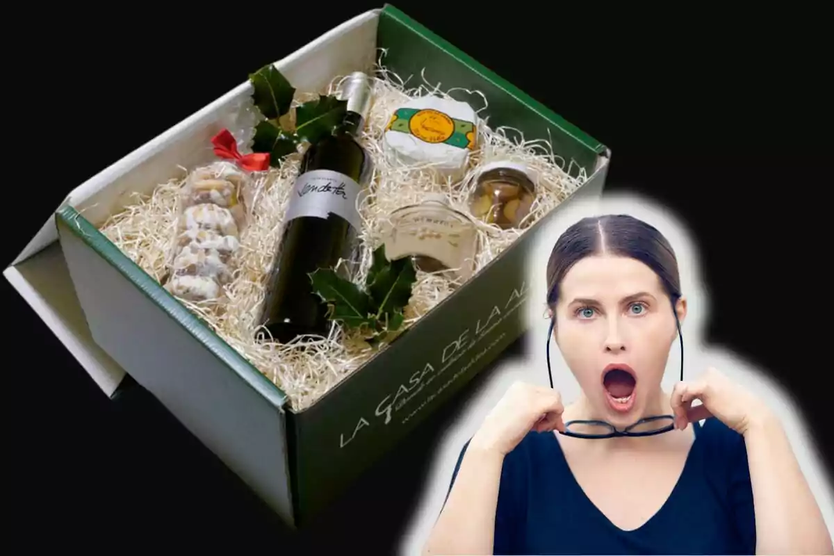 Una caja de regalo con productos gourmet, incluyendo una botella de vino, queso y otros alimentos, junto a una persona sorprendida.