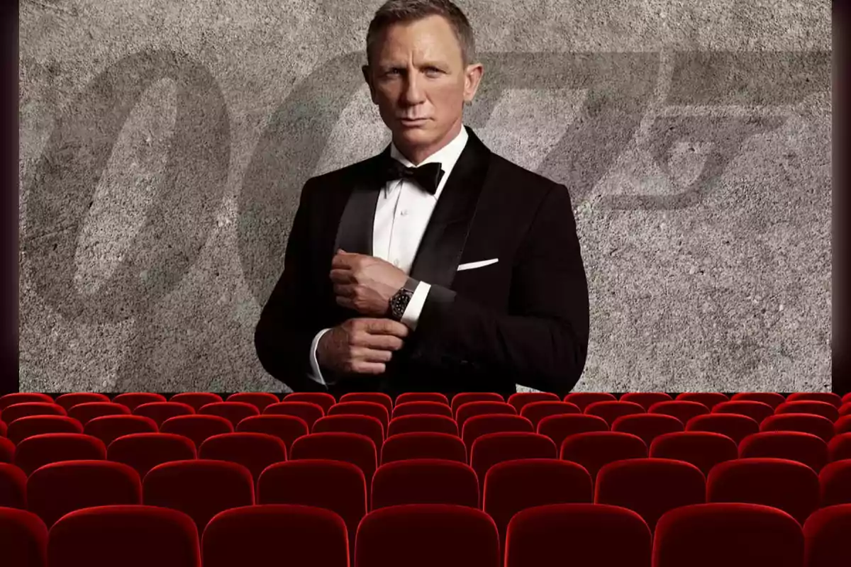 Un hombre en esmoquin aparece en una pantalla de cine con asientos rojos en primer plano y un fondo con el número 007.