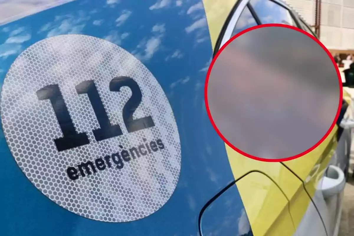 Un coche de emergencias con el número 112 visible en un círculo blanco y negro en la puerta, con una sección de la imagen desenfocada dentro de un círculo rojo.