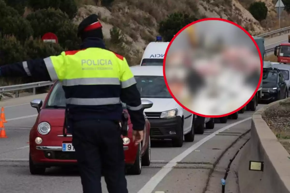 Un agent de policia de trànsit atura vehicles en una carretera mentre s?observa una fila de cotxes.