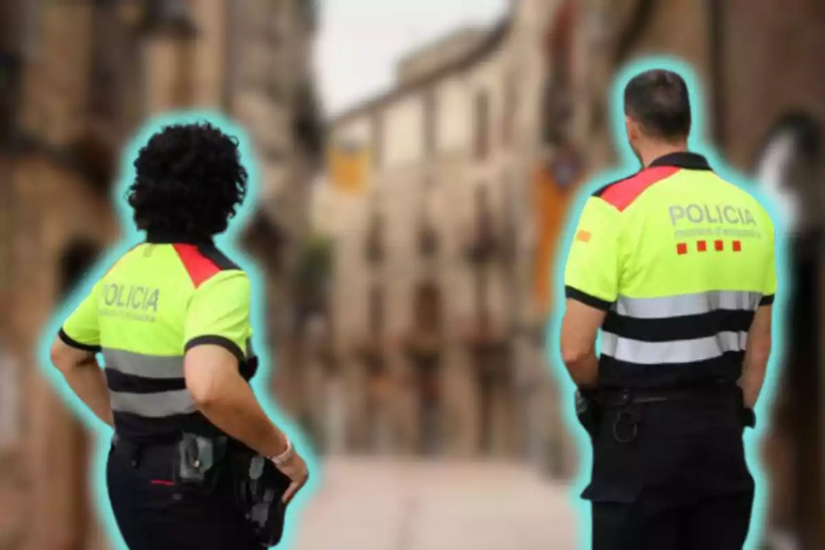 Dos agents de policia amb uniformes d'alta visibilitat patrullen un carrer urbà.