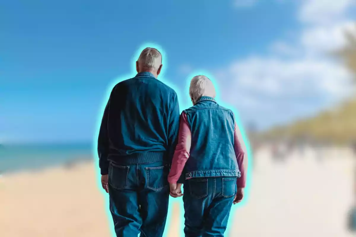 Una pareja de ancianos caminando de la mano en la playa con un efecto de resplandor azul a su alrededor.