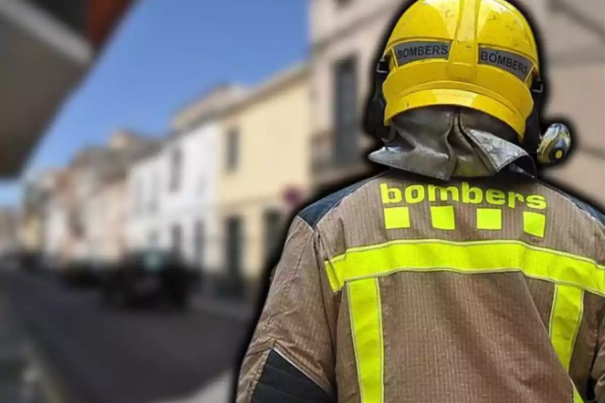 Bomber d´esquena amb casc groc i uniforme amb detalls reflectants en un carrer urbà.