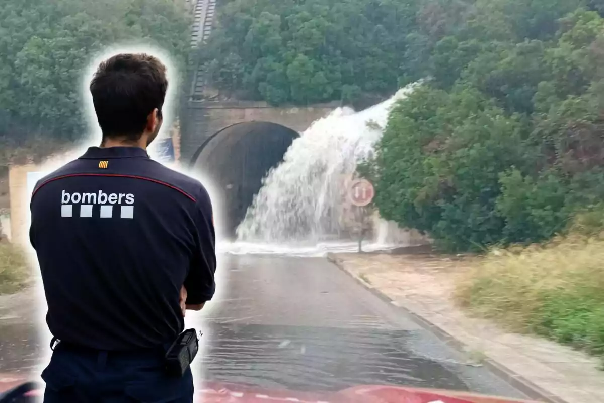 Un bomber observa una gran quantitat daigua sortint dun túnel, possiblement a causa duna inundació.