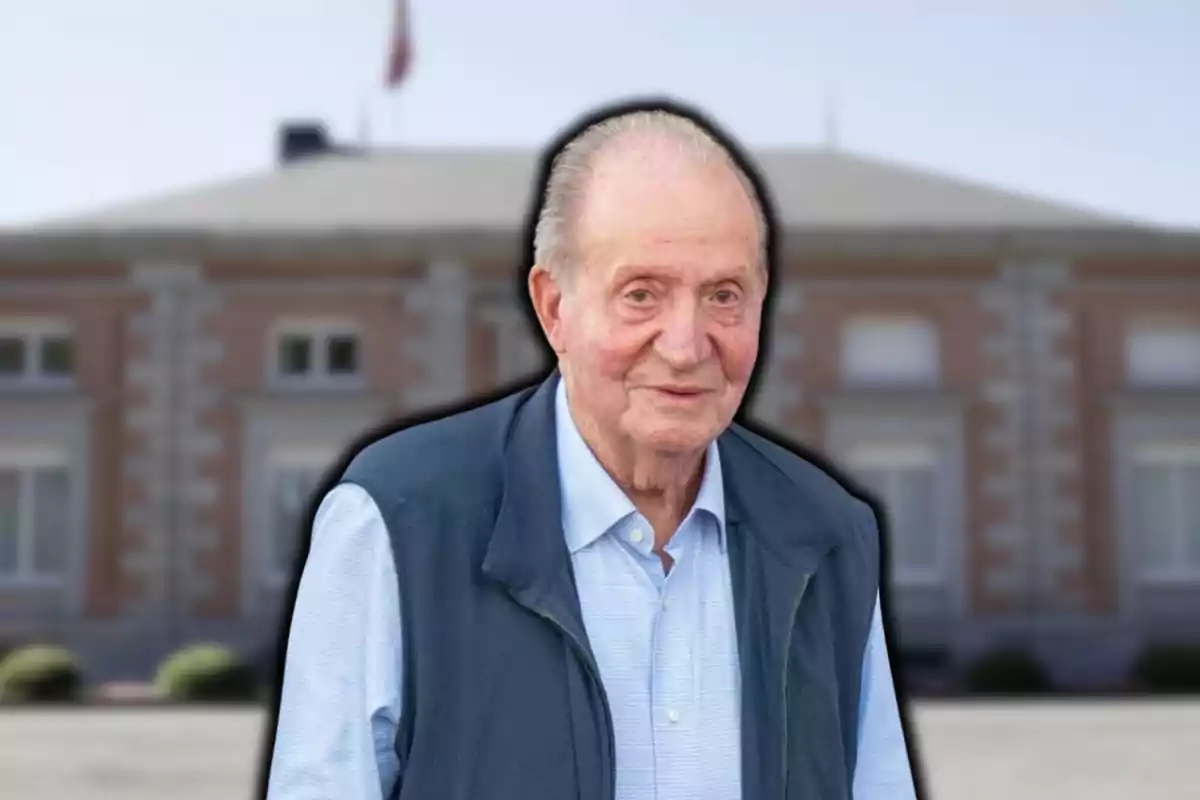 Un hombre mayor con chaleco azul frente a un edificio de ladrillo.