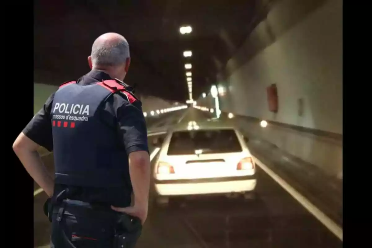 Un agente de policía observa un coche detenido en un túnel.