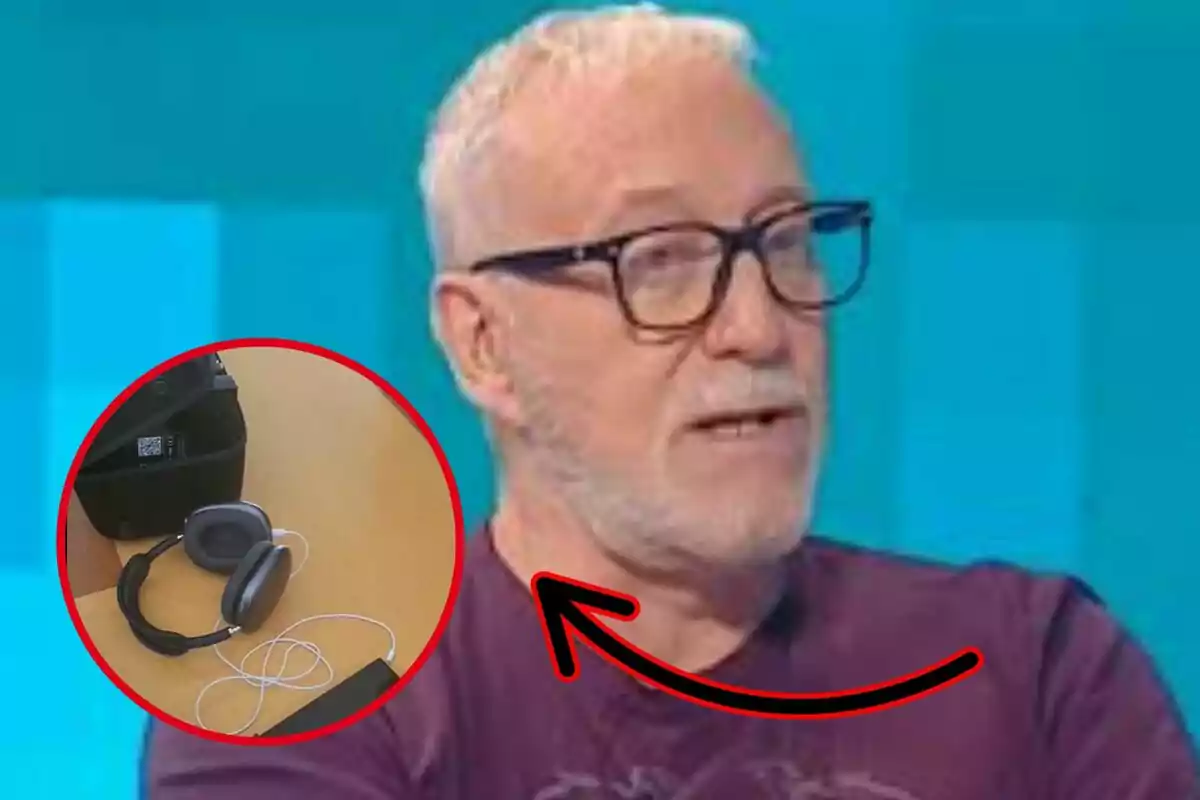 Home de cabells canosos i ulleres parlant a la televisió amb un cercle vermell que ressalta uns auriculars i un cable sobre una taula