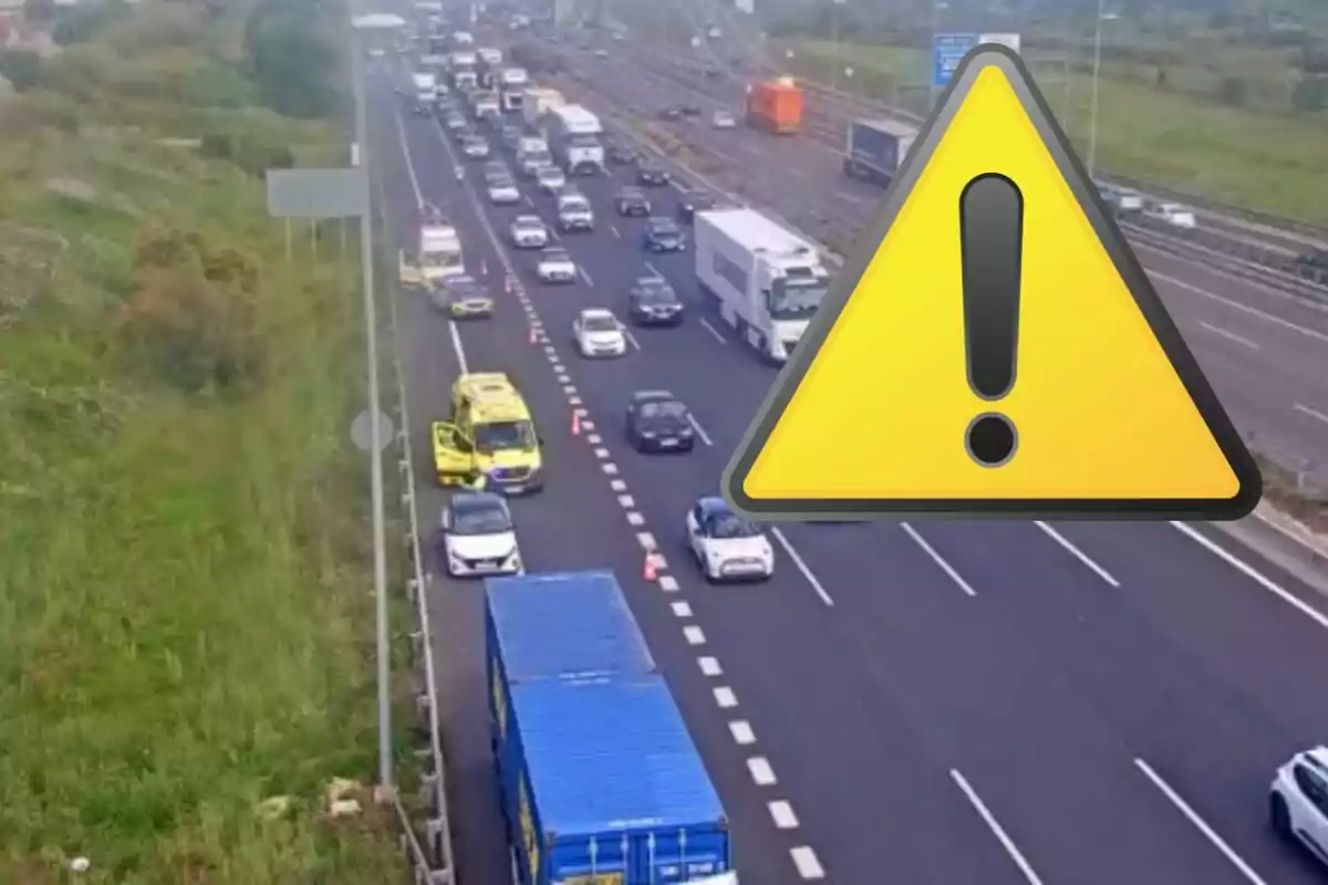 Una carretera con tráfico denso y vehículos de emergencia en el carril izquierdo, con un gran icono de advertencia superpuesto.
