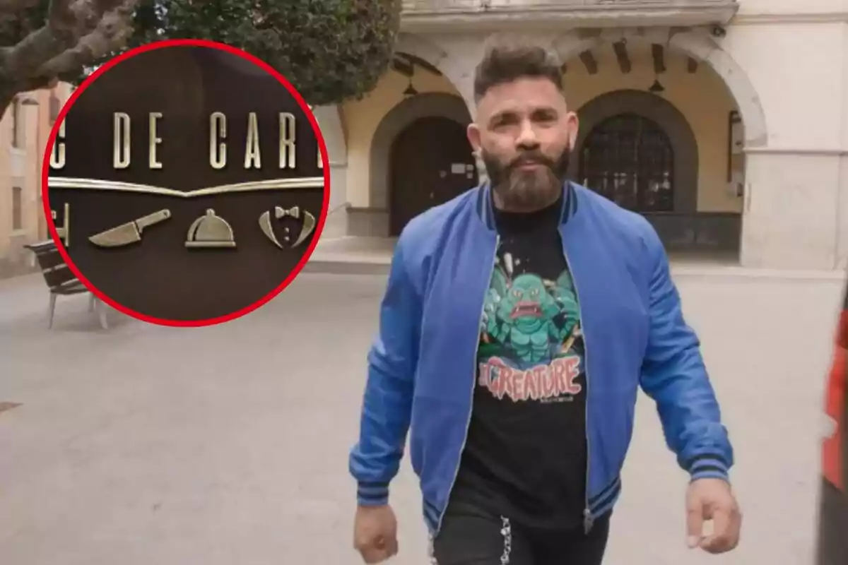 Un hombre con barba y chaqueta azul camina por una plaza, lleva una camiseta con un diseño colorido; en la esquina superior izquierda hay un círculo rojo que muestra un logotipo con utensilios de cocina.