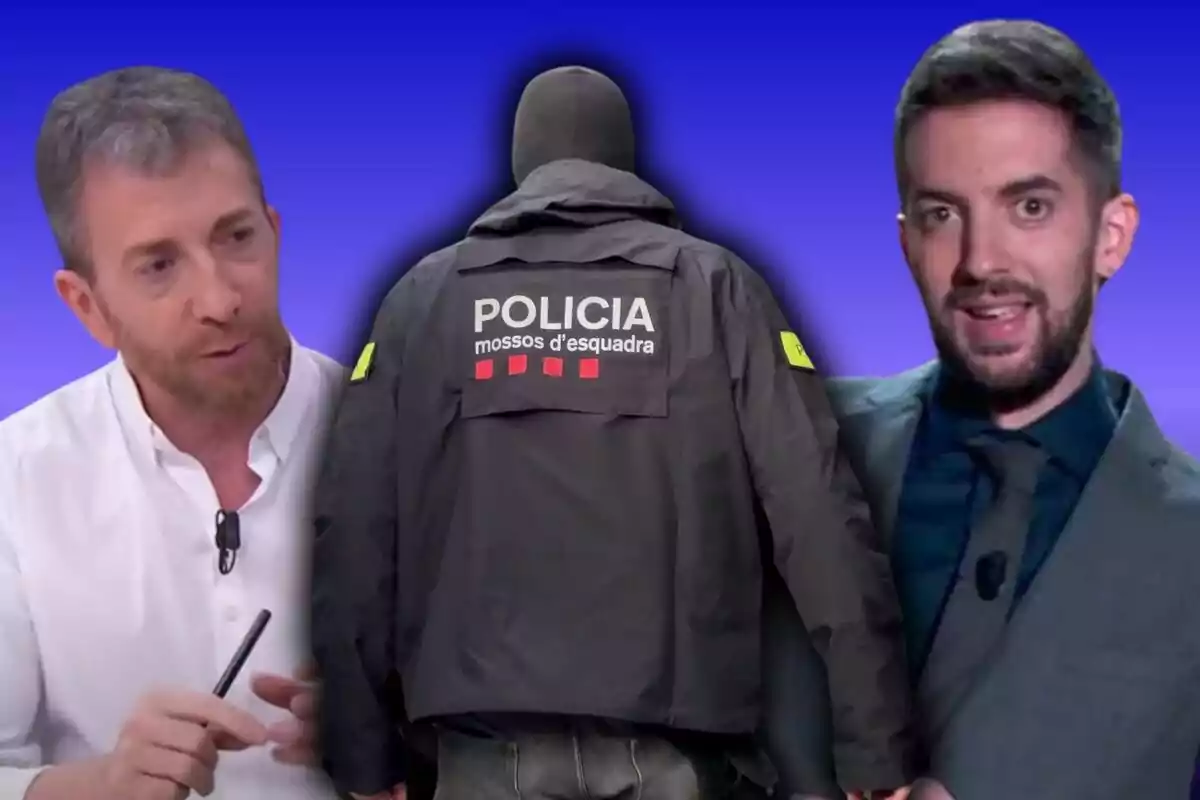 Dos hombres flanquean a un policía de espaldas con una chaqueta que dice "Policía Mossos d'Esquadra" sobre un fondo azul.