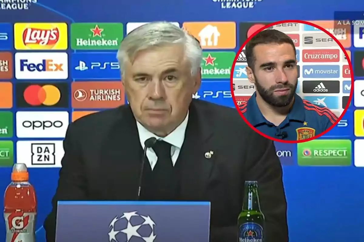 Un hombre en una conferencia de prensa de la UEFA Champions League con un micrófono frente a él y un fondo lleno de logotipos de patrocinadores, junto a un recuadro que muestra a otro hombre con una camiseta de la selección española.