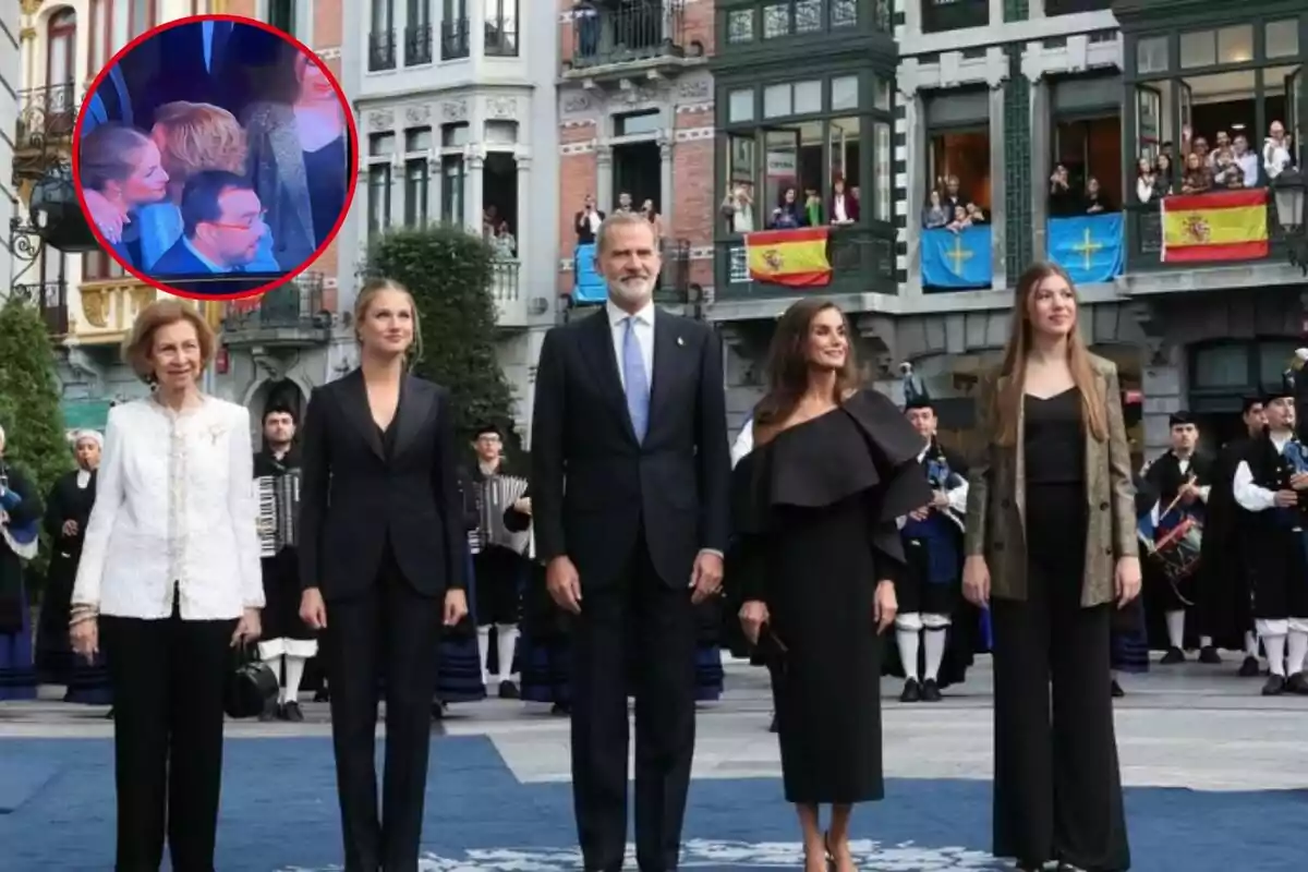 Un grupo de personas posando en una ceremonia oficial al aire libre, con banderas y espectadores en los balcones de fondo.