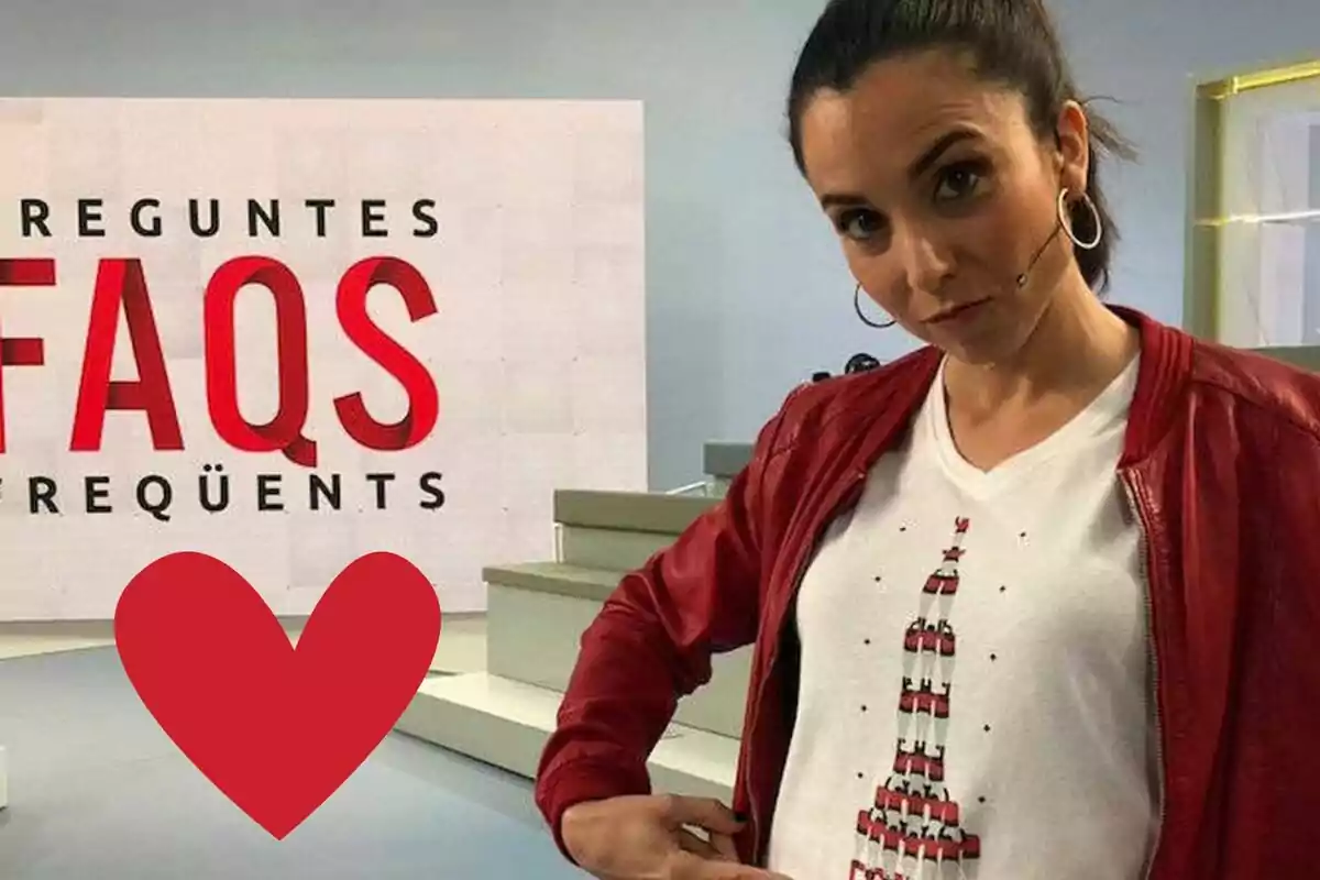 Una persona con chaqueta roja y camiseta blanca está frente a un cartel que dice "Preguntes Freqüents" con un corazón rojo superpuesto en la imagen.