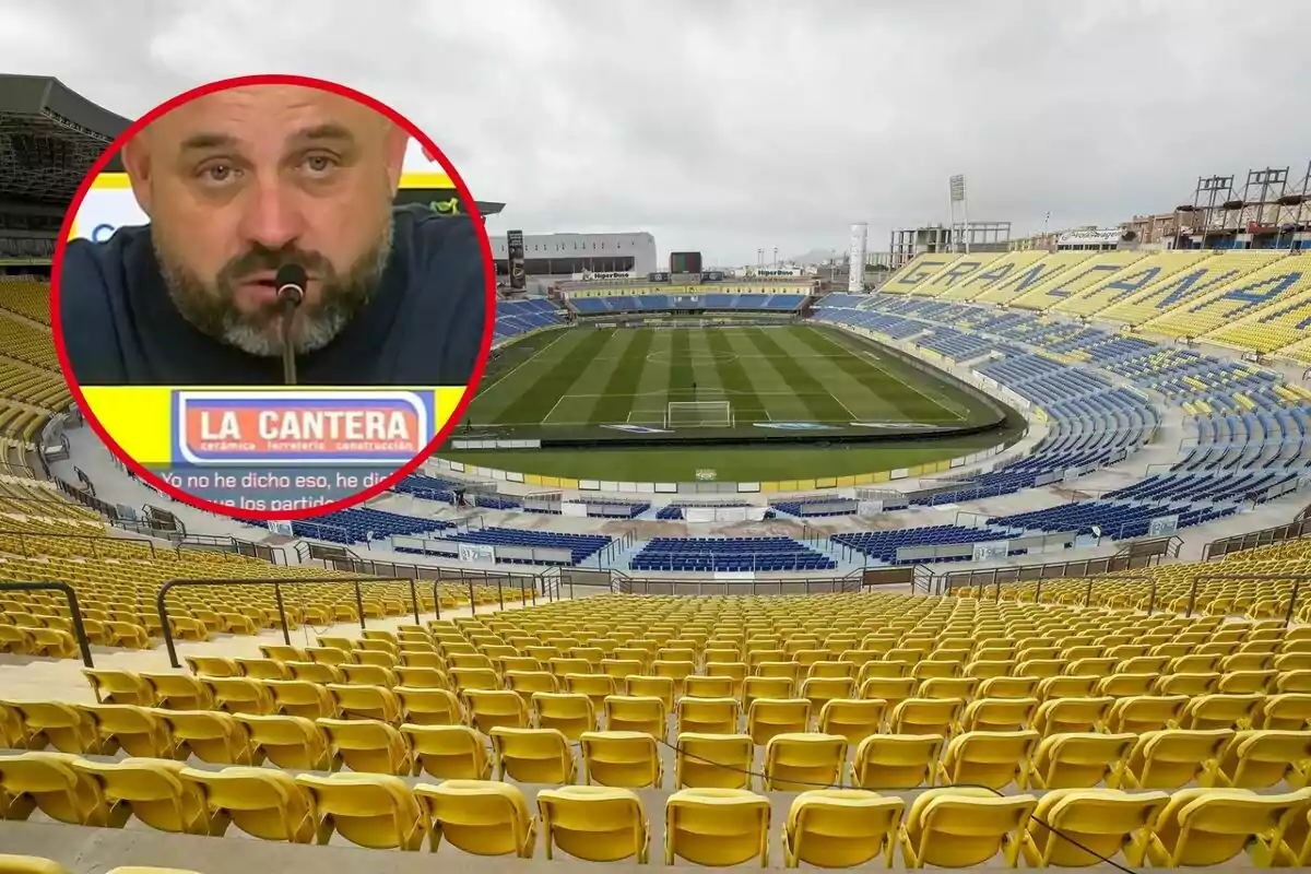 Un estadi de futbol buit amb seients grocs i blaus i un requadre que mostra un home parlant en una conferència de premsa.