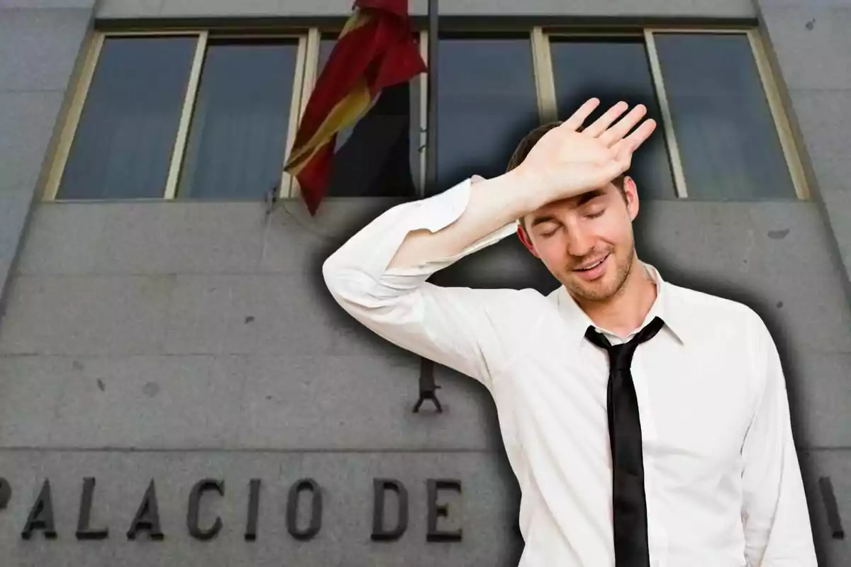 Un hombre con camisa blanca y corbata negra se seca el sudor de la frente frente a un edificio con una bandera roja y amarilla.