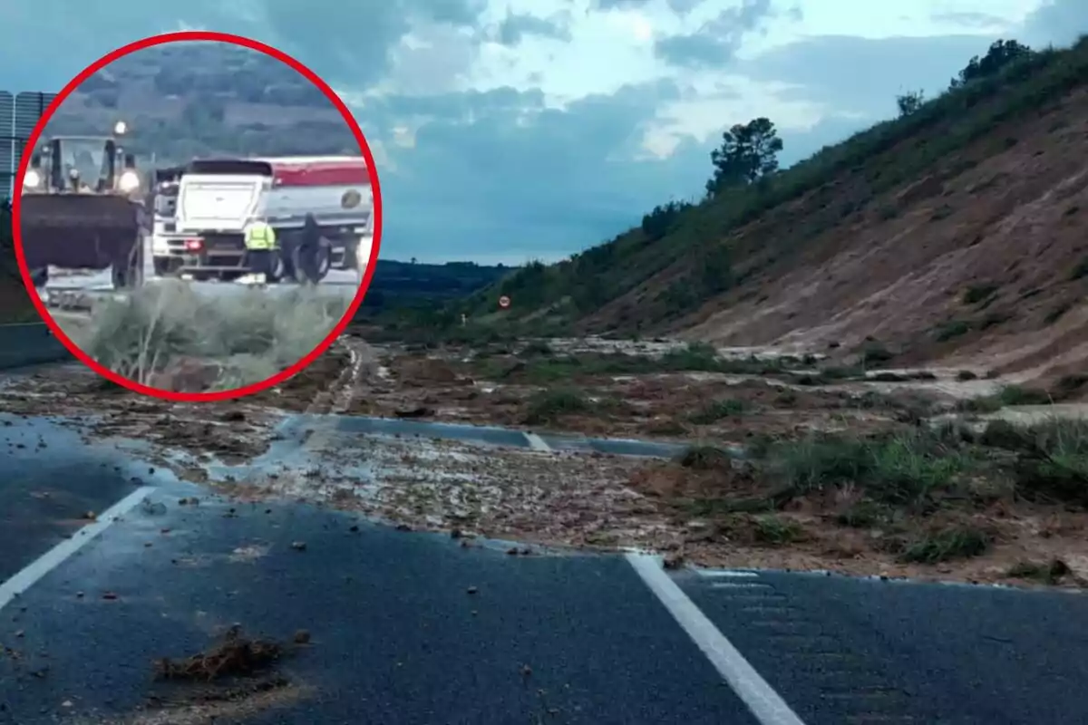 Carretera cubierta de lodo tras un deslizamiento de tierra con maquinaria trabajando en la limpieza.