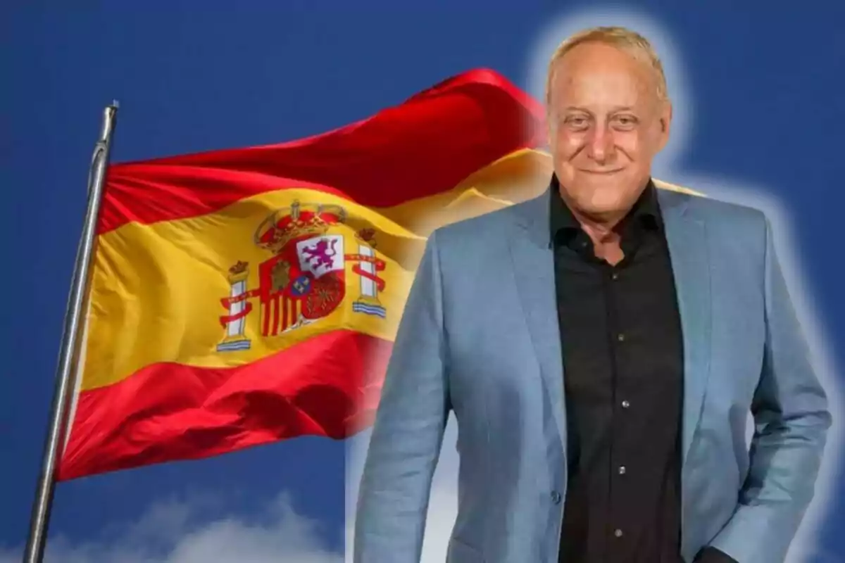 Un home amb jaqueta blava davant d'una bandera d'Espanya onejant.