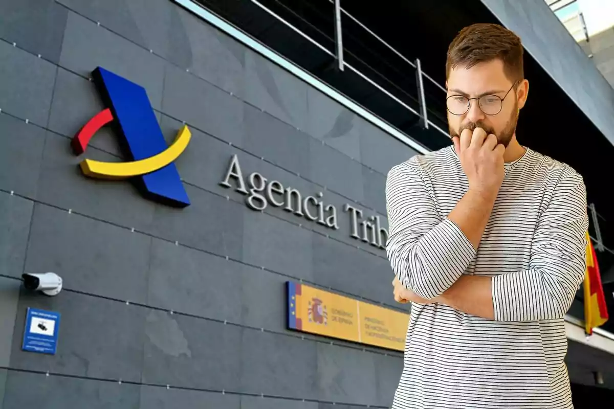 Un hombre con expresión pensativa frente a un edificio de la Agencia Tributaria.