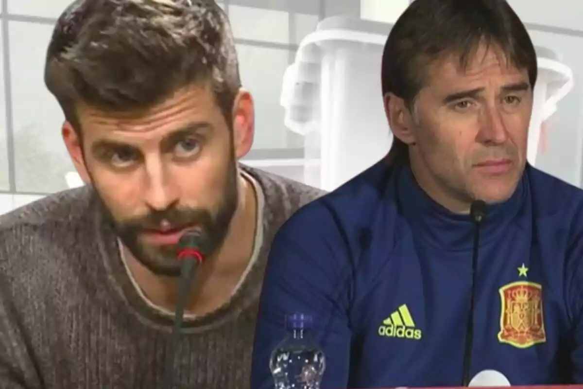 Dos hombres en una conferencia de prensa, uno con suéter gris y barba, el otro con chaqueta deportiva azul con el escudo de España.