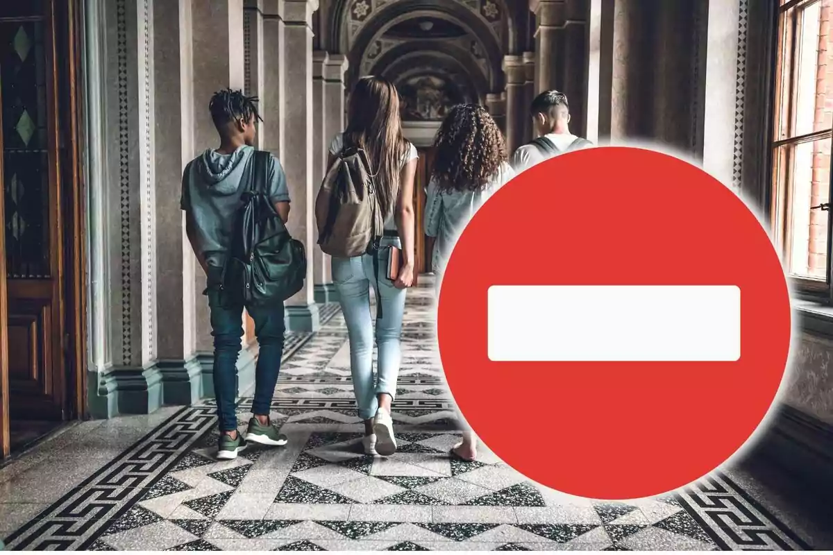 Un grup de joves caminant per un passadís amb un símbol de prohibit en primer pla.