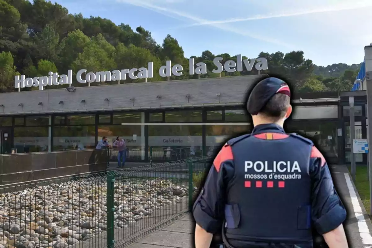 Un agente de policía de espaldas frente al Hospital Comarcal de la Selva.