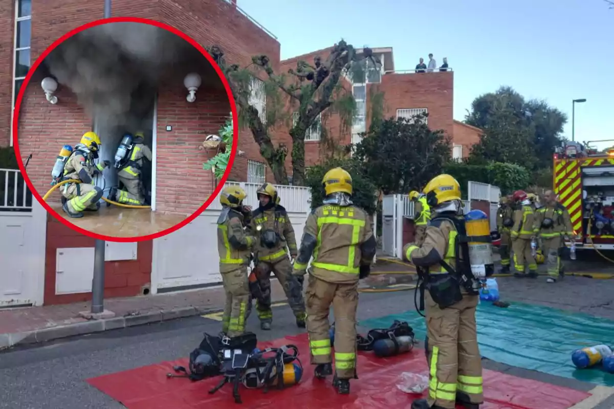 Bombers treballant en l?escena d?un incendi en un edifici residencial, amb fum sortint d?una porta mentre altres bombers es preparen fora.