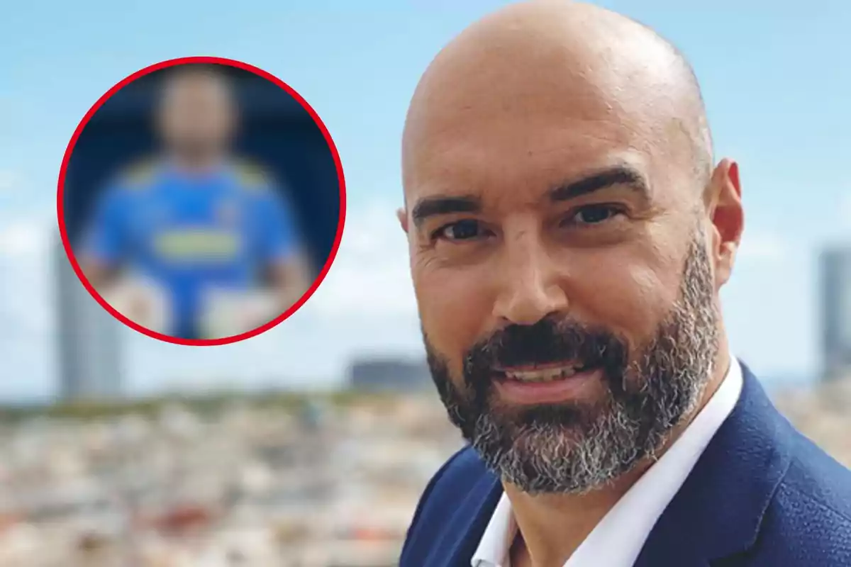 Un hombre con barba y cabeza rapada sonríe al aire libre con un fondo urbano desenfocado y un círculo rojo con una imagen borrosa en la esquina superior izquierda.