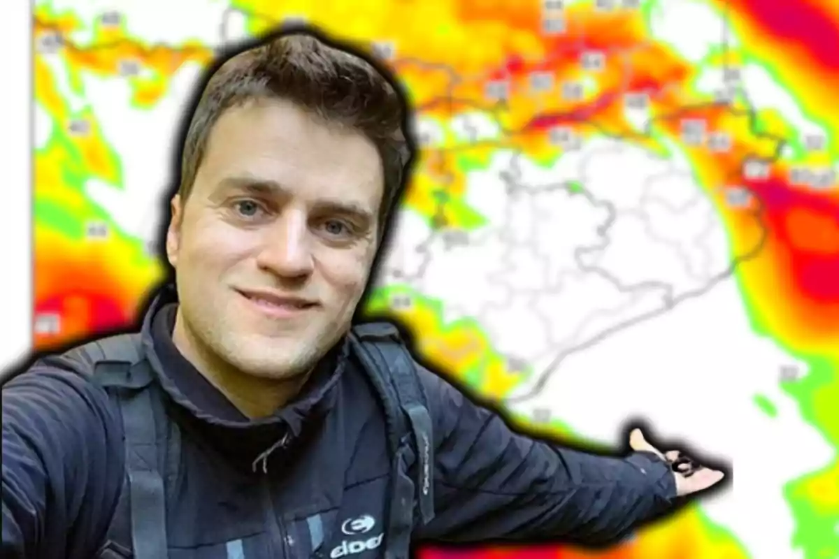 Un hombre sonriente con chaqueta oscura posa frente a un mapa meteorológico colorido.