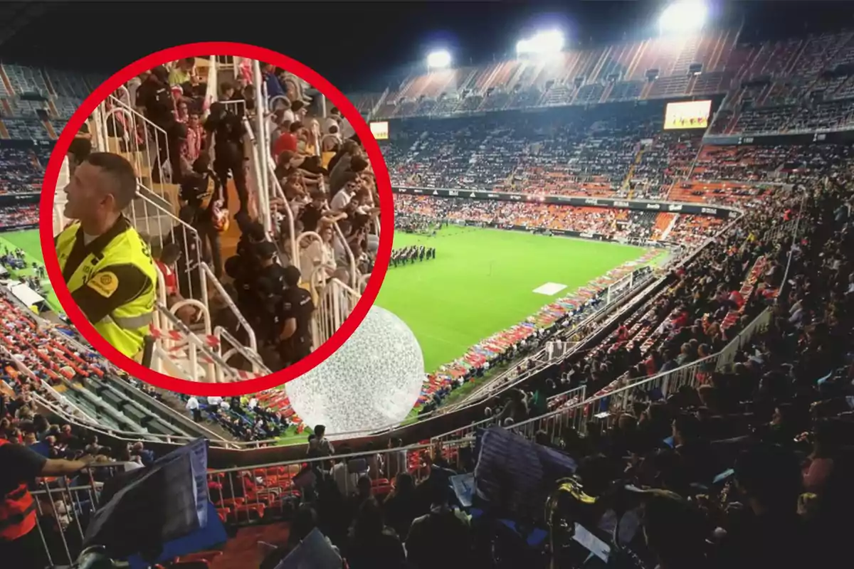 Estadio de fútbol lleno de espectadores con un círculo rojo resaltando una sección donde hay policías y un guardia de seguridad.