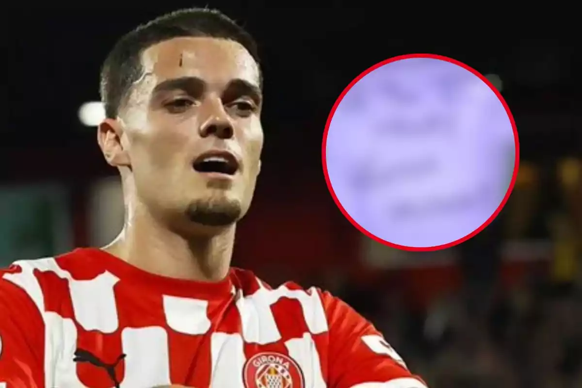 Jugador de fútbol con camiseta a cuadros rojos y blancos en el campo de juego.