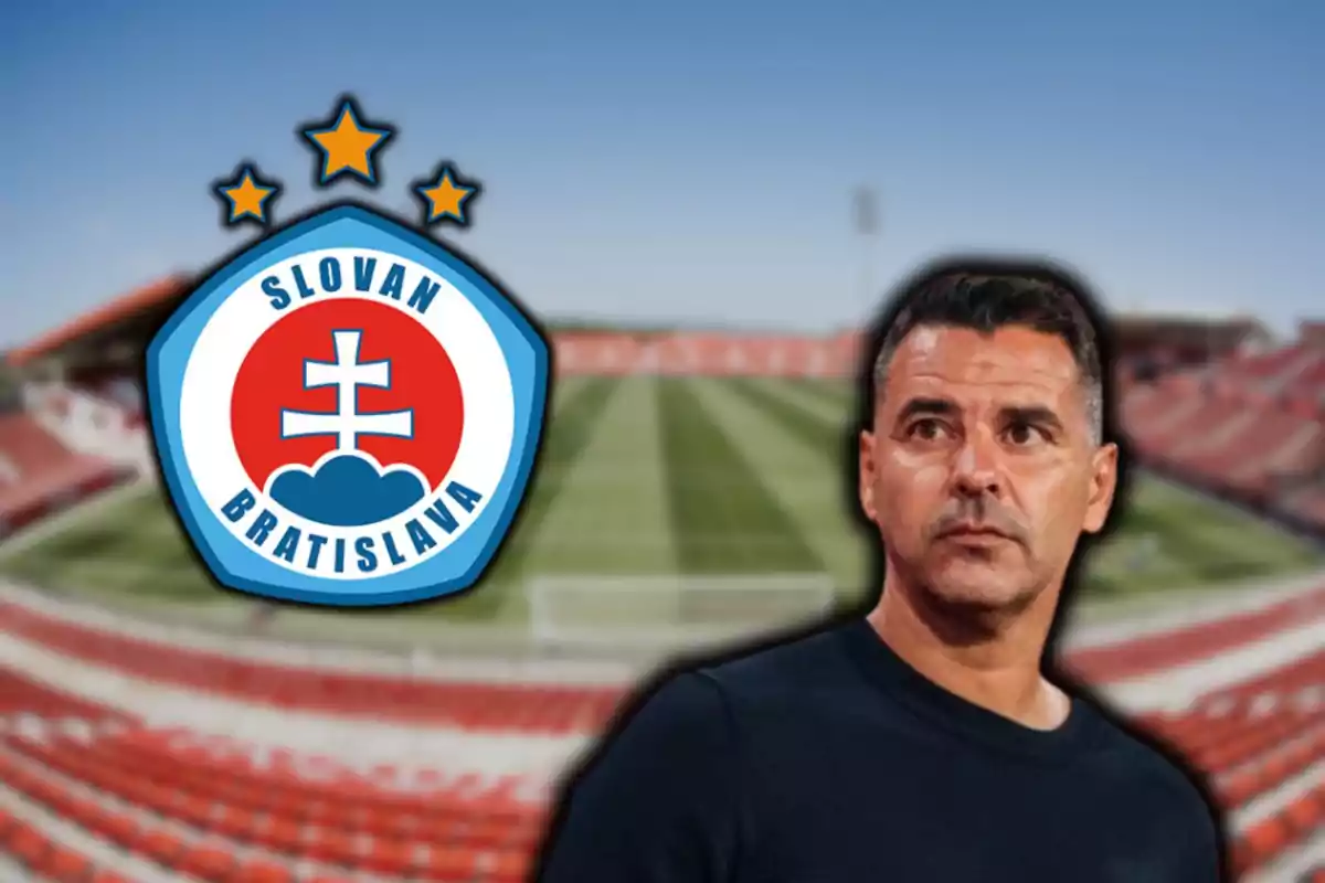 Un hombre con una camiseta oscura está frente a un estadio de fútbol desenfocado y al lado del escudo del Slovan Bratislava.