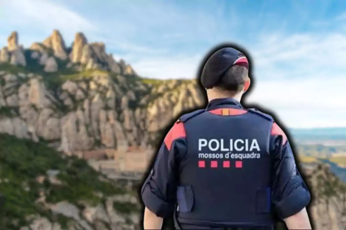 Un agent dels Mossos d'Esquadra d'esquena amb un paisatge muntanyós de fons.