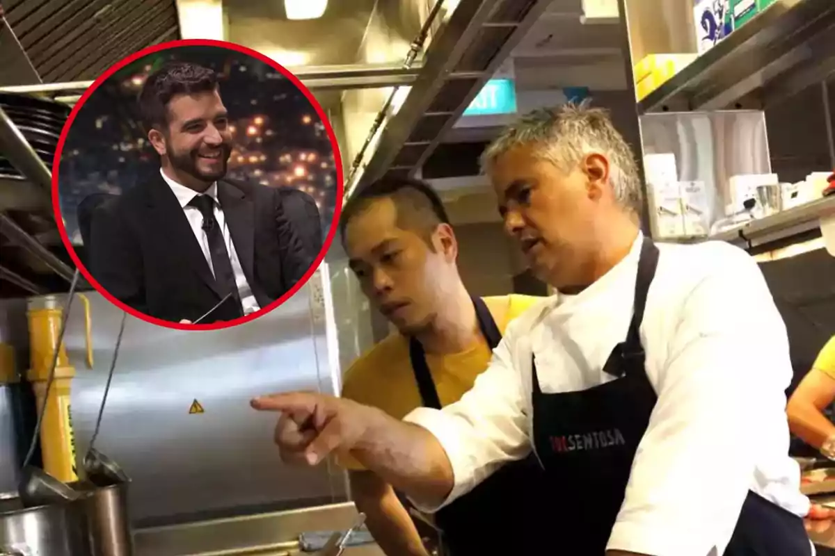 Un chef en una cocina señalando algo a un compañero mientras en un recuadro se ve a un hombre sonriendo en un programa de televisión.