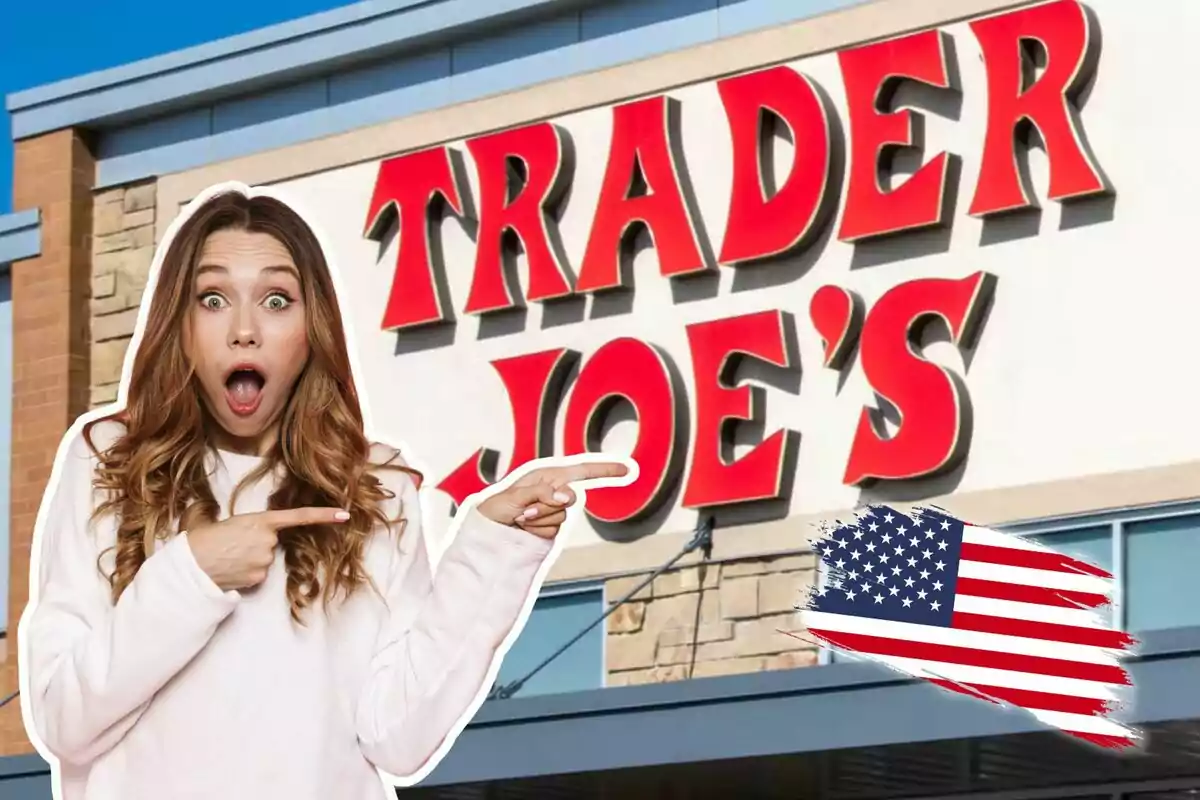 Una mujer sorprendida señala hacia el letrero de una tienda Trader Joe's con una bandera de Estados Unidos en la esquina.