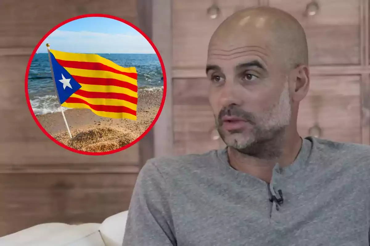 Un hombre con barba y camiseta gris está sentado en un sofá con una imagen de una bandera con franjas amarillas y rojas y un triángulo azul con una estrella blanca en el fondo.