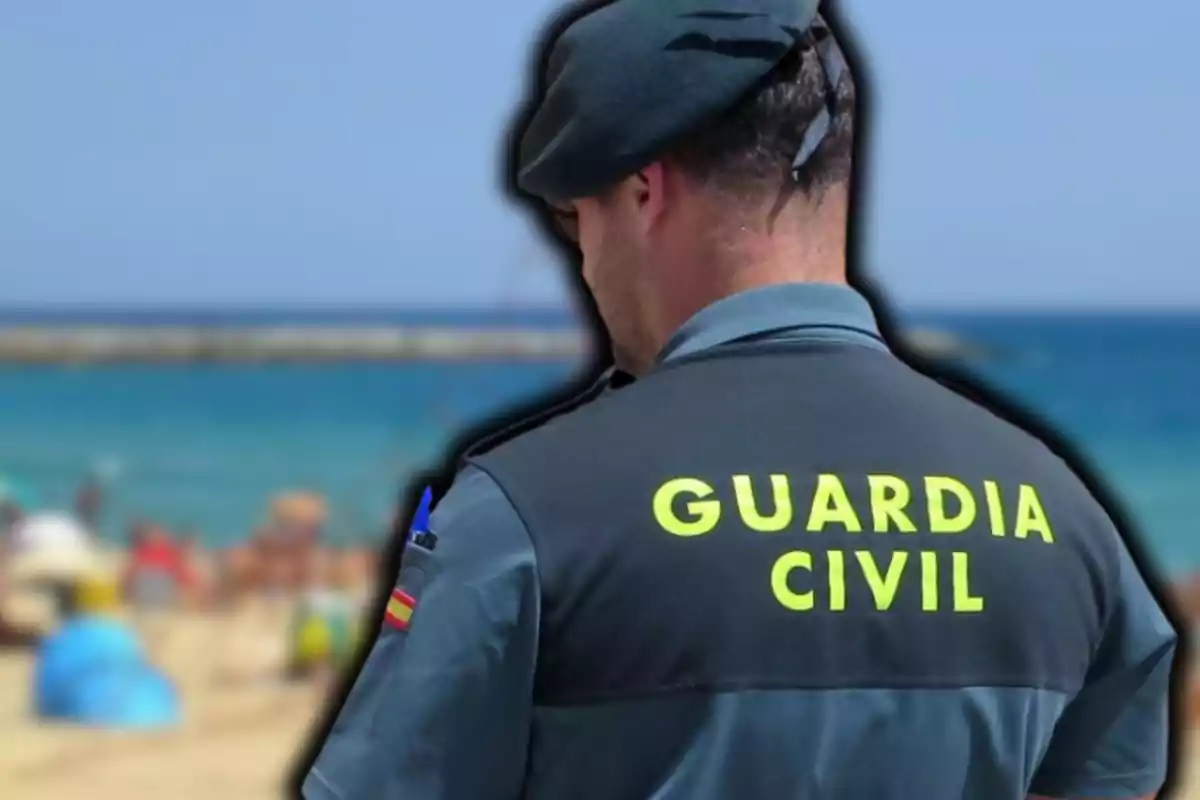 Un agente de la Guardia Civil de espaldas en una playa.