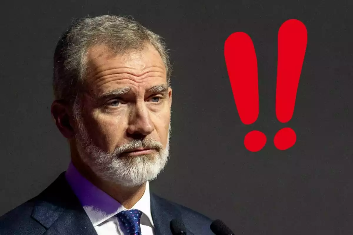 Felip VI amb vestit fosc al costat de signes d'exclamació vermells.